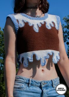 a woman wearing a brown and white crop top with crochet on the bottom