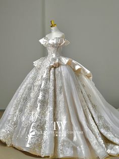 a white wedding dress on display in front of a wall with the word love written on it