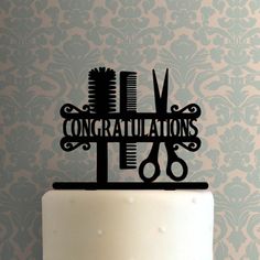 a cake topper with scissors and combs on it that says randye in black