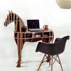 a horse shaped desk with a laptop on it and a chair in front of it