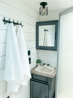 a bathroom with two white towels hanging on the wall and a sink in the corner