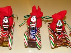 three candy canes with santa clause decorations on them