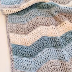 a crocheted blanket laying on top of a white table