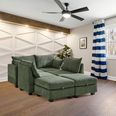 a living room with a green couch and striped curtains