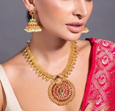 HAND CRAFTED JEWELLERY DESCRIPTION *Gold plated temple jewellery set *Gold plated necklace, has an embellished circular centrepiece, secured with drawstring fastening *A pair of embellished gold plated jhumka earrings, has a floral base, a dome-shaped dangler and pearl-like beaded drops *Secured with a post-and-back closure *Size:- Length of the necklace: 16 cm Length of the earrings: 5 cm *Material:- Material: Brass Plating: 24K gold-plated *Care:- Wipe with a clean cotton swab when needed NOTE All the raw material used in this product is of high quality and is handcrafted with love. Premium Quality and High craftsmanship 100% Satisfaction Guarantee: Long Lasting Plating, High-Quality Stones. Our jewellery is individually handcrafted by master artisans using meticulous crafting techniques Indian Long Necklace, Stone Temple, Rani Haar, Temple Jewelry, Polki Necklace, Jewelry Indian, Jhumka Earrings, Ruby Stone, Temple Jewellery