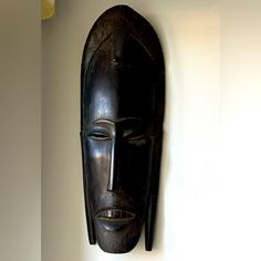 a wooden mask hanging on the wall