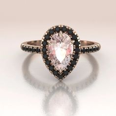 Stunning pear shape Morganite engagement ring. This ring is made in solid 14K Rose Gold. The center stone is surrounded by a delicate halo set with genuine Black Diamonds as well as the shank (0.25ct). Pink And Black Engagement Ring, Engagement Ring With Black Accents, Black Pear Engagement Ring, Black Diamond Pear Engagement Ring, Color Engagement Rings Vintage, Black Diamond Rose Gold Engagement Ring, Black Diamond Engagement Ring Halo, 14k Rose Gold Jewelry, Black Diamond Wedding Rings