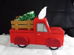 a red truck with a christmas tree in the back