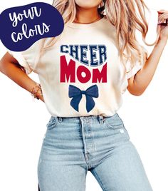 Cheer Mom Shirt Custom Colors for Cheerleading Moms | Personalized Team Colors with Custom Bow 🎀 | Cheerleader Mom Gift Tee Description: Show off your team spirit with this custom Cheer Mom shirt! Perfect for supporting your cheerleader with pride, this tee allows you to personalize both the team colors and the bow 🎀 to match your cheer squad's colors. *Customizable Design: Choose your team's colors and personalize the bow 🎀 for a unique, spirited look. *Comfortable Fit: Made from soft, high- Cheerleading Graphic Print Fan Apparel Tops, Multicolor Cotton Tops With Team Name, Summer Short Sleeve Cheerleading Tops, Short Sleeve Tops For Cheerleading In Summer, Summer Short Sleeve Tops For Cheerleading, School Spirit Tops For Summer Cheerleading, School Spirit Tops With Team Name, Summer School Spirit Tops For Cheerleading, Summer Cheerleading Tops With School Spirit Style