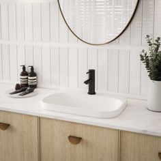 a bathroom sink sitting under a mirror next to a wooden cabinet and white counter top