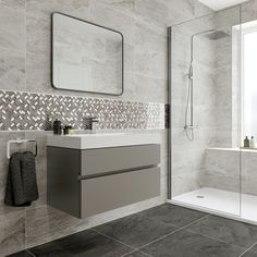 a bathroom with grey tiles and white fixtures