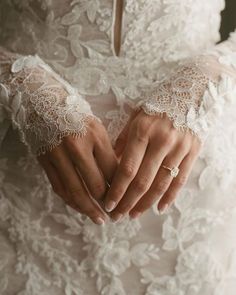 a woman in a wedding dress holding her hands together