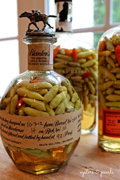 a bottle filled with beans sitting on top of a wooden table next to two bottles