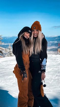 two women standing next to each other in the snow