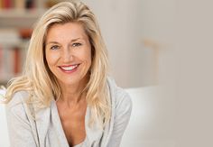 a woman sitting on a couch smiling at the camera