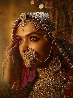 a woman with makeup and jewelry on her face, wearing an elaborate headdress