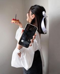 a woman holding an iphone in her hand