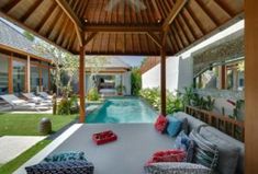 an outdoor living area with couches, tables and a swimming pool in the background