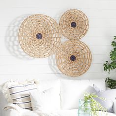 three wicker circles hang on the wall above a white couch