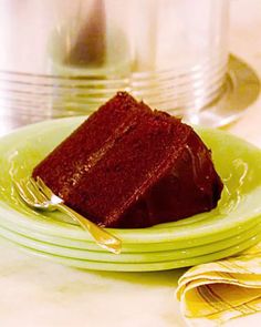 a piece of chocolate cake sitting on top of green plates