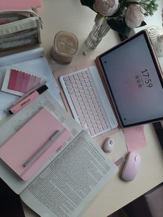 an ipad, keyboard and mouse on top of a desk with pink flowers in the background