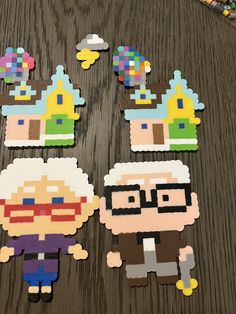 several pieces of paper cut out to look like pixelated characters on a table with crayons