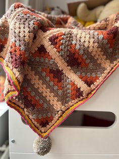 a crocheted blanket on top of a white chair