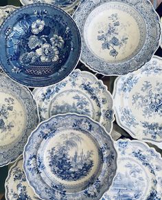 many blue and white plates stacked on top of each other