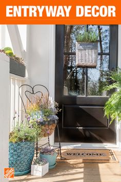 an entryway decorated with potted plants on the front porch and welcome sign above it