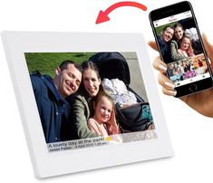 a hand is holding an iphone and taking a picture with a family photo on the screen