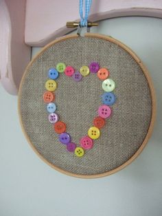 a heart made out of buttons hanging on a wall