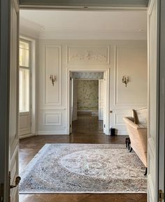 an open door leading to a living room with a rug on the floor in front of it