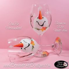 two wine glasses with painted snowmen and carrots on them, sitting next to each other