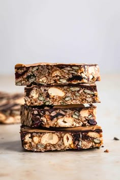 three granola bars stacked on top of each other with nuts and seeds in the middle