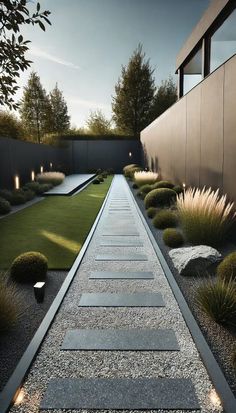 an outdoor garden with grass, rocks and gravel path leading to a house in the background