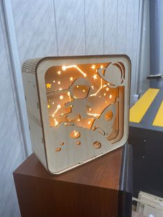 a wooden box with an image of a person on it and lights in the shape of a clock