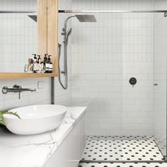 a white bathroom with black and white floor tiles on the shower wall, sink and mirror