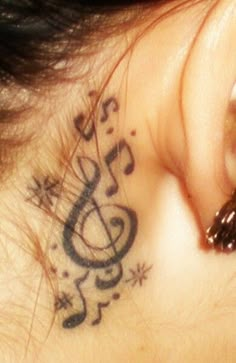 a close up of a person's ear with musical notes on it