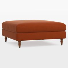 an orange ottoman sitting on top of a white floor