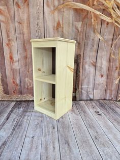 a wooden shelf sitting on top of a wooden floor next to a wood plank wall