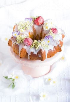 a bundt cake with white icing and strawberries on top