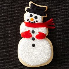 a cookie shaped like a snowman wearing a hat and scarf