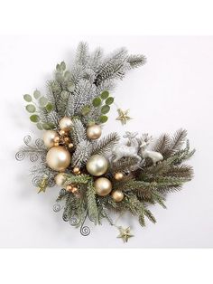 a christmas wreath with ornaments and greenery on the wall in front of a white background