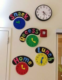 several colorful clocks on the wall with words and numbers written in different languages to spell out their time