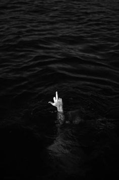 a hand sticking out of the water with it's fingers up in the air