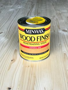 a can of wood finish sitting on top of a wooden floor