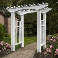 a white garden arbor with pink flowers in the background