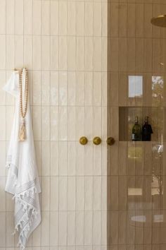 a white towel is hanging on the wall next to a shower door with gold knobs