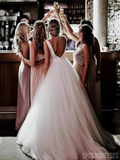 the bride and her bridesmaids are toasting each other in front of the bar