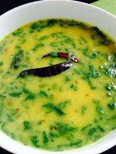 a white bowl filled with green soup on top of a table